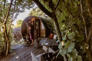 赫纲兰德Vakantiewoning met sauna & hottub en zwempoel op Natuurterrein的木甲板,配有桌子和圆顶帐篷