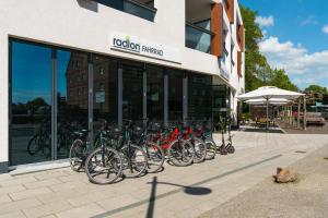 瓦伦Radlon Fahrrad-Komfort-Hotel的停在大楼前的一排自行车