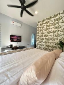 Kampung MawarChantara Cottage的卧室配有一张白色大床和吊扇