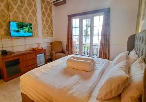 吉利特拉旺安Gili Beachfront Suites的卧室配有一张床,墙上配有电视。