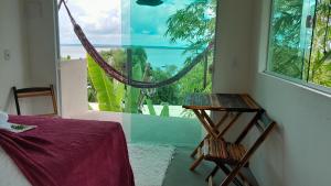 甘博阿Beija Flor的一间卧室设有一张桌子和一个美景窗户。