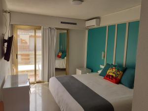 甘迪亚Hotel Clibomar Jamaica的一间带大床的卧室和一个阳台