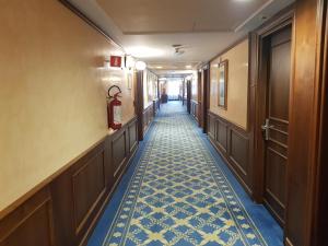 圣多纳托-米拉内塞桑塔芭芭拉酒店的一条铺着蓝色和白色瓷砖地板的酒店走廊