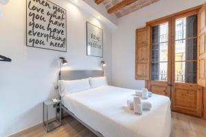 巴塞罗那格拉西亚中心公寓的卧室配有白色的床和窗户。