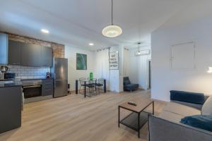 巴塞罗那格拉西亚中心公寓的客厅以及带沙发和桌子的厨房。