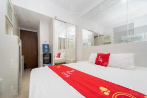 日惹RedLiving Apartemen Vivo Yogyakarta - WM Property的一间卧室配有一张床铺,床上铺有红色毯子