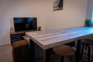 勒芒Bonuit的客厅设有一张大木桌,配有电视