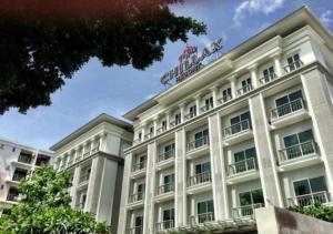 曼谷奇莱克斯度假酒店 - SHA Extra Plus的白色的建筑,上面有标志