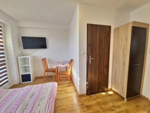 梅尔诺U Sławuli的一间带桌椅的卧室和一间带门的房间