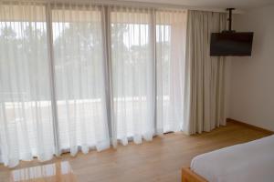 皮奇勒姆Ruka Lobos的卧室设有大窗户和白色窗帘