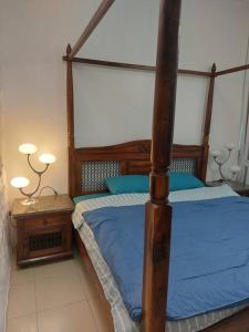 阿吉曼apartment in Ajman for 4 persons near the sea的一间卧室配有一张带蓝色床单的天蓬床