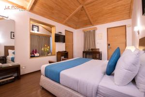 科代卡纳尔Le Poshe, Kodaikanal的一间卧室配有一张带蓝色枕头的大床