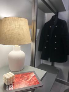 罗马Soha Piazza Di Spagna Boutique的桌子上的一盏灯,上面有杂志和衣架上的外套