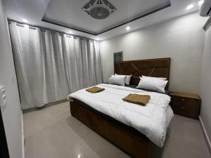 拉合尔3 bed Luxurious Apartment DHA PH8的一间卧室配有一张大床和两条毛巾