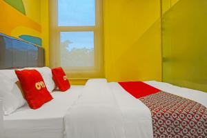 当格浪SUPER OYO 92271 Orienchi 3的黄色客房 - 带两张床和窗户