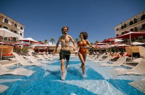 马贝拉Hard Rock Hotel Marbella - Puerto Banús的男人和女人走进游泳池