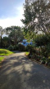 莫列马阿Appart Cosy Green, Océan, Golf, Piscine, Wifi的蓝色房子前面的道路