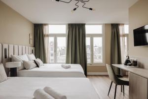 阿姆斯特丹Adam Suites Hotel的酒店客房配有两张床和一张书桌