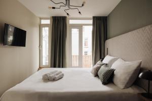 阿姆斯特丹Adam Suites Hotel的卧室配有一张大白色床和窗户