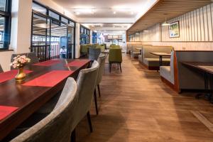 内罗毕Samra Hotel的餐厅设有木桌、椅子和红色餐巾