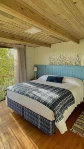 格拉玛多Cabana Mirim Estalagem Rural的卧室内的一张床铺,设有木制天花板
