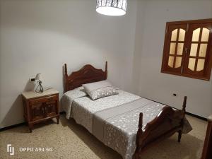 Cruce de ArinagaCasa Guanche II的一间卧室配有一张床和一张带台灯的桌子