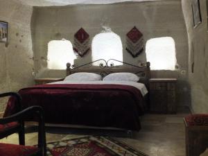 格雷梅Anatolia cave hotel Pension的一间卧室设有一张大床和两个窗户