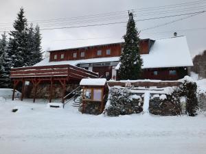 小莫拉夫卡Chata Resort Na Horské的前面的地面上积雪的建筑