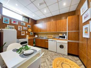 大雅茅斯Spacious apartment with Sea Views on Great Yarmouth Seafront的带木制橱柜和桌子的厨房以及带冰箱的厨房。