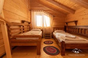 沃罗赫塔Girska Hatyna Vorohta的小木屋内一间卧室,配有两张床