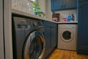安纳隆Irish Sea Cottage的蓝色洗衣房内的洗衣机和烘干机