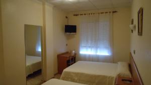 马萨龙港罗斯西斯奈旅馆的一间小卧室,配有两张床和窗户
