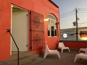 圣胡安拉埃斯坦西亚度假公寓的红色的建筑,设有两把椅子和一扇门