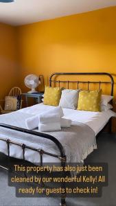 斯沃德林科特Goodwins' by Spires Accommodation a comfortable place to stay close to Burton-upon-Trent的一间卧室配有一张黄色墙壁的床