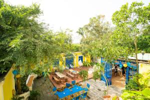 会安The Cuckoo's Nest Hostel and Bar managed by Hoianese的餐厅享有高空的景色,设有蓝色的桌子和树木