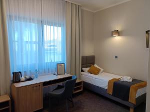 卢布涅维采Leśne Niebo的酒店客房配有一张床、一张书桌和一台笔记本电脑