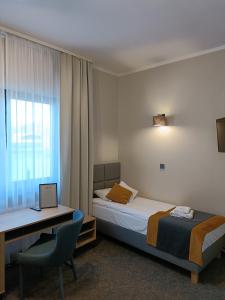 卢布涅维采Leśne Niebo的酒店客房配有一张床、一张书桌和一台笔记本电脑