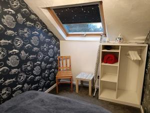 卡姆尔福德Poppy's Place Annex in Camelford North Cornwall的一间卧室配有一张床、一张桌子和一把椅子