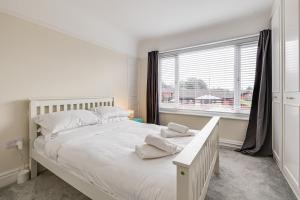 利物浦Elegant 3 Bed House near Liverpool City Centre的卧室设有一张白色大床和一扇窗户。