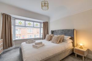 利物浦Elegant 3 Bed House near Liverpool City Centre的一间卧室设有一张大床和窗户
