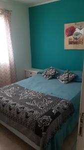 乌斯怀亚Rocio的一间卧室配有一张蓝色墙壁的床