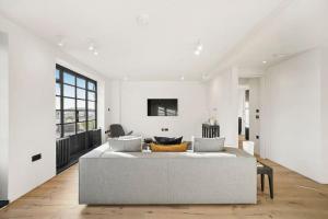 伦敦Two Bedroom Flat in Kensington的白色的客厅配有沙发和桌子
