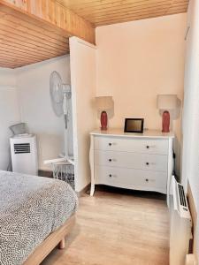 Ruelle-sur-TouvreJolie maison 2 chambres - CLIM MOBILE - TV - Proche d un lac的卧室配有白色的床和梳妆台。