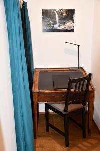 瓦森Hof-Fankhauser的一张带椅子的木桌,旁边是蓝色窗帘