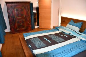 瓦森Hof-Fankhauser的一间卧室配有一张带蓝色毯子的床