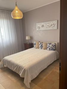 菲乌米奇诺La casa di Flora aeroporto di Fiumicino的卧室配有带蓝色枕头的大型白色床
