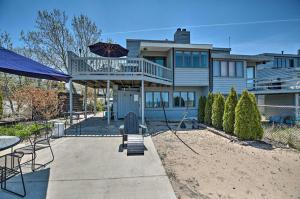 GaryLakefront Family Retreat with Grill Steps to Beach!的房屋设有带甲板和遮阳伞的天井