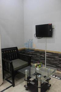 卡拉奇Sk Travellers Inn的一间带椅子和桌子的房间以及一台电视
