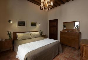皮恩扎PienzaLettings "Casa Olivieri"的一间卧室配有一张床、镜子和吊灯