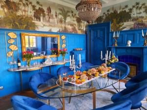 BayonChateau Tanesse de Tourny的蓝色的用餐室配有玻璃桌和蓝色的椅子